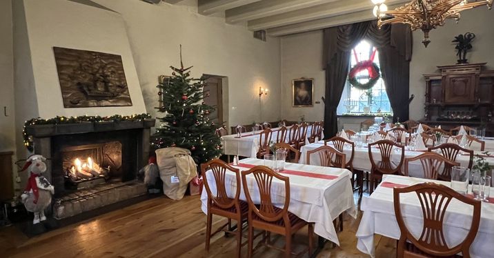 Slottets matsal med brasa och juldekor.