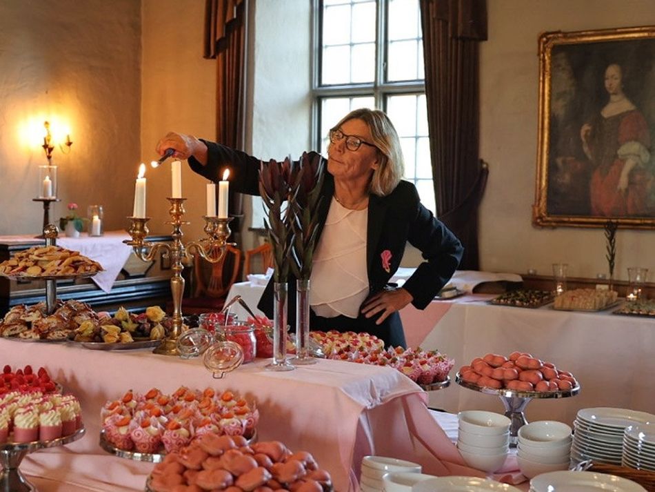 Restaurangchefen Maria tänder ljus på afternoon tea buffén i slottets matsal.